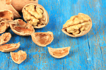 Broken walnuts on wooden table close-up