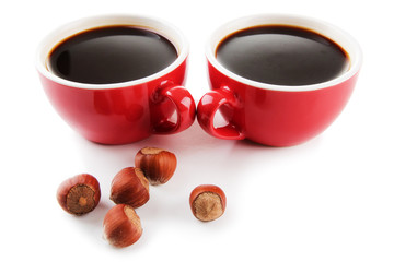 Red cups of strong coffee and nuts isolated on white