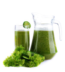 Glass and jug of green vegetable juice with cucumber isolated