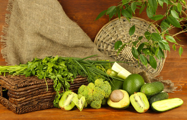 Fresh green vegetables and fruits, on wooden background