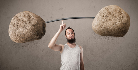 skinny guy lifting large rock stone weights