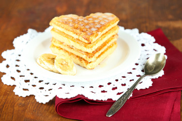 Sweet Belgium waffles with banana, on wooden table background