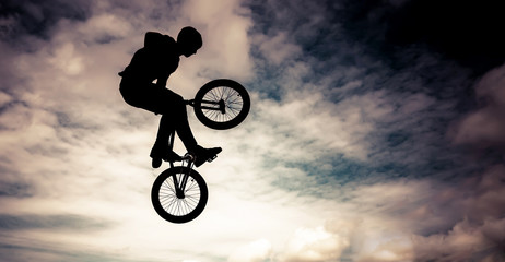 Obraz premium Silhouette of a man doing an jump with a bmx bike.