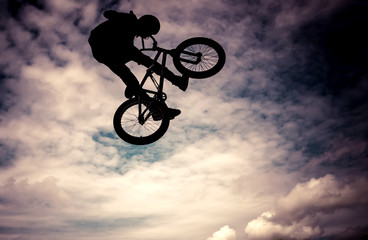 Fototapeta premium Silhouette of a man doing an jump with a bmx bike.
