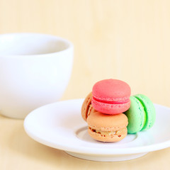 Colorful macaroons and cup of coffee with retro filter effect