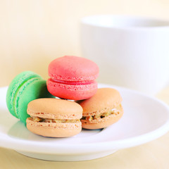 Colorful macaroons and cup of coffee with retro filter effect