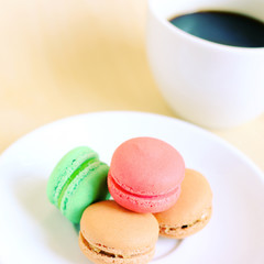 Colorful macaroons and cup of coffee with retro filter effect