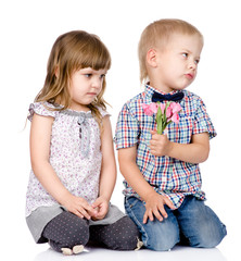 resentful boy gives to the girl a flower. isolated on white back