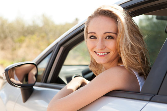 junge lachende frau im autofenster sommer