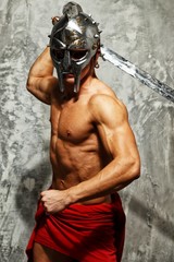 Fototapeta na wymiar Gladiator with muscular body with sword and helmet
