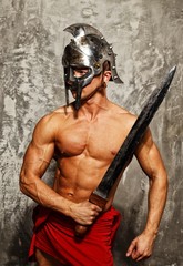 Gladiator with muscular body with sword and helmet
