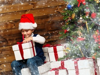 Obraz na płótnie Canvas Little boy with gift box under christmas tree 