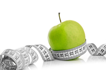 Measuring tape wrapped around a green apple