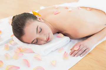 Fototapeta na wymiar Beautiful woman resting on towel at beauty spa