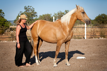 Fototapeta na wymiar junge weibliche reiterin trainiert ihr pferd im freien im sommer
