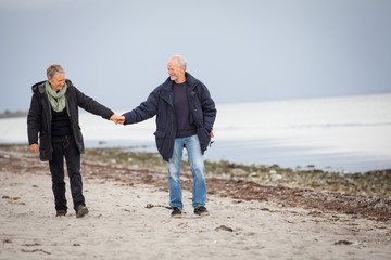 älteres glückliches paar macht einen strand spaziergang
