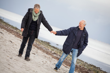 älteres glückliches paar macht einen strand spaziergang