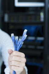 Close up of young man holding a bunch of computer cables