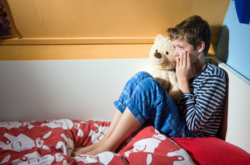 Boy crying on his bed