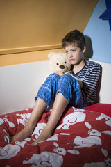 Sad and depressed boy on his bed