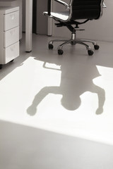 Shadow of business person on the floor with arms raised cheering