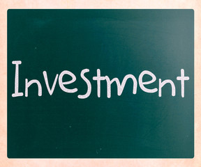 The word 'Investment' handwritten with white chalk on a blackboa