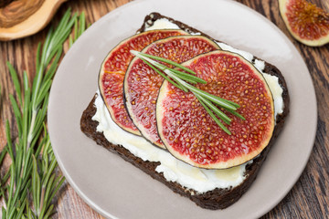 bread with goat cheese, fresh figs, honey and rosemary, top view