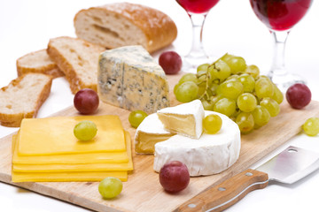 Cheese platter, grapes, bread and red wine on board