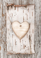Wooden heart with birch bark on the old wood