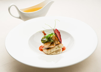 Bowl with fish fillet and dish with hot broth
