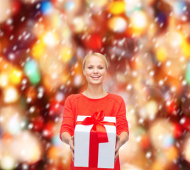 Fototapeta na wymiar smiling woman in red sweater with gift box
