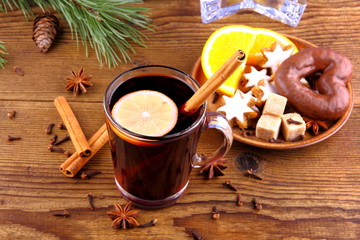 Mulled wine in glass with cinnamon stick and sweets