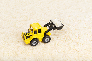 Industrial tractor toy on the rice seeds