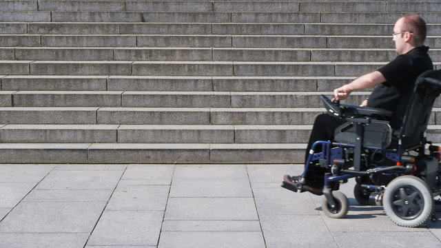 disabled person in a wheelchair on top of an inaccessible stairc
