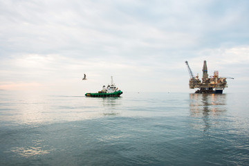 Oil rig being tugged in the sea