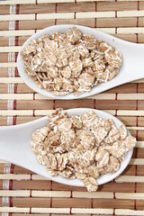 wheat flakes on white ceramic spoon