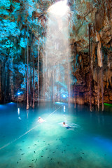 Cenote Dzitnup, Mexico. Blurred couple swimming
