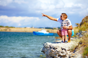 happy father and son on the cliff near the lake