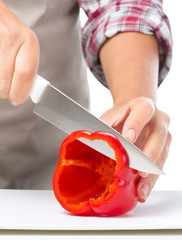 Cook is chopping bell pepper