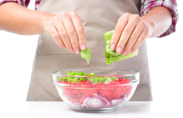 Obraz na płótnie Canvas Cook is tearing lettuce while making salad