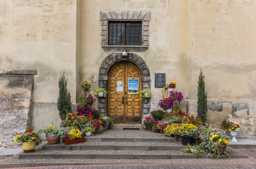 Fototapeta na wymiar Kroków do drzwi kościoła, ozdobione kwiatami