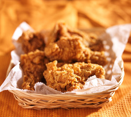 crispy fried chicken in basket on orange table cloth