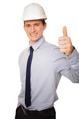 Young businessman standing  in a helmet shows finger up.