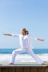 Fototapeta premium senior woman doing warrior yoga pose