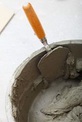 dirty trowel and bucket on building site