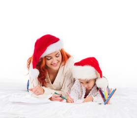 A mother and daughter in Christmas hats drawing with markers