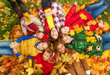 Kids lay on the autumn grass