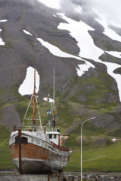 Fototapeta Old fishing boat and mountain. Iceland. Siglufjordur.