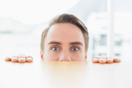 Portrait of businessman looking over blurred wall at office