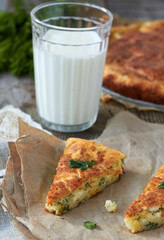 Two slices of  pie with  cheese and dill and glass of milk